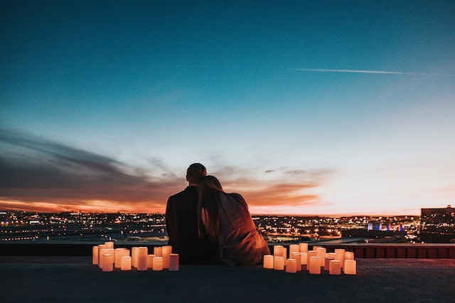 couple overlooking city scene surrounded by candles around them
