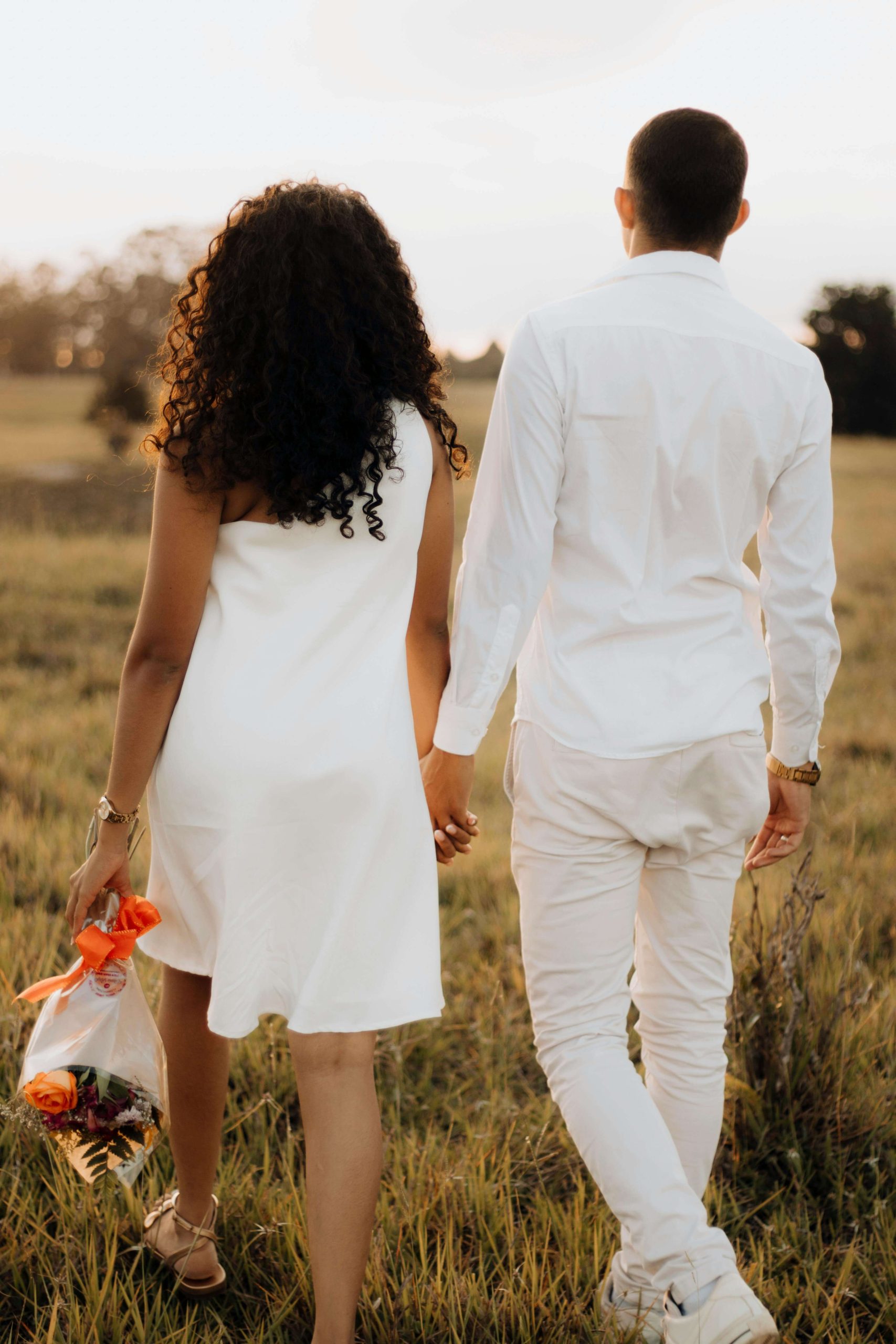 couple holding hands walking outdoors, symbolizing healing attachment wounds in adult relationships with Los Angeles trauma therapist