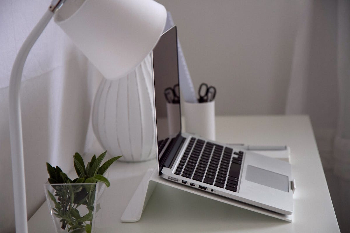 Laptop on a white desk symbolizing calm and focus for online attachment-based therapy in California.