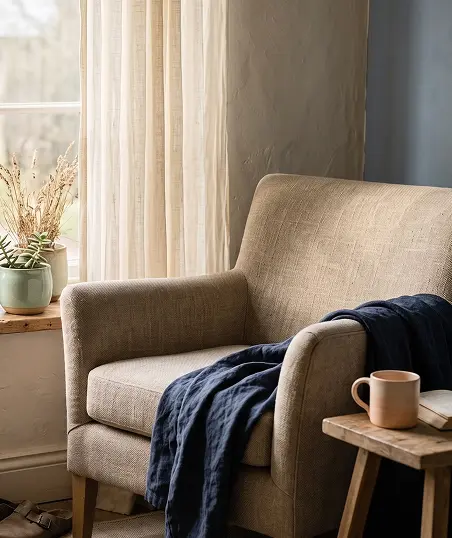 A wooden chair and a small table positioned beside a large window.