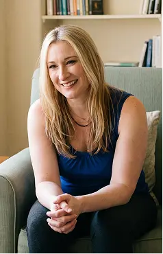 A smiling woman seated on a couch